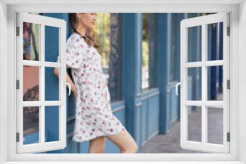 Girl stands leaning against the wall