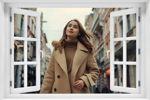 A sophisticated young woman walks through the city in a stylish beige coat, projecting fashion and independence