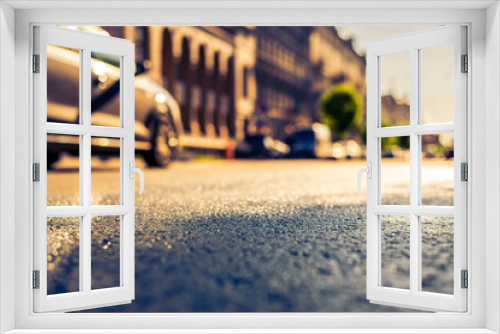 City on a sunny day, a quiet city street after rain on which passsing car