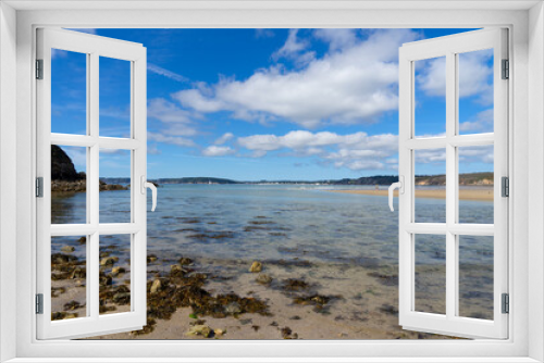 Fototapeta Naklejka Na Ścianę Okno 3D - Algues brunes flottant dans des eaux transparentes, sous un ciel bleu parsemé de nuages blancs, sur la presqu'île de Crozon en Bretagne.