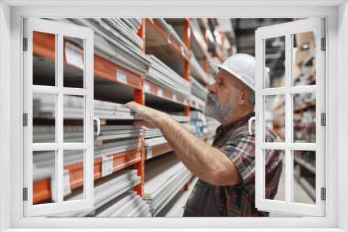 A homeowner selecting new drywall sheets at a hardware store for a major repair project