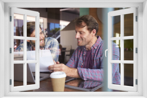 Two Businessmen Working On Laptop In Coffee Shop