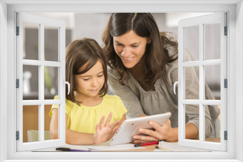 mother and daughter doing homework with a tablet