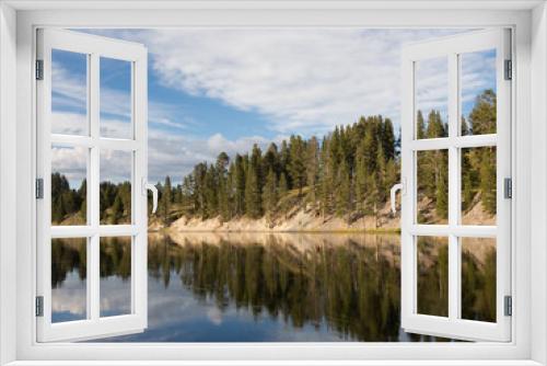 Fototapeta Naklejka Na Ścianę Okno 3D - Scenic view of the mirror like water surface of the Yellowstone River and partly cloudy blue sky, Yellowstone National Park.
