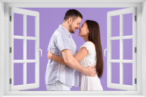 Young couple hugging on lilac background