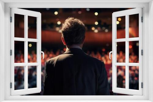 A speaker stands before a large audience