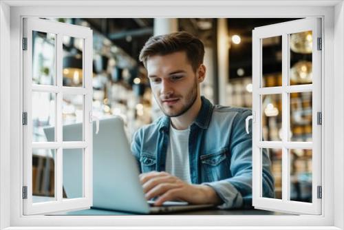 High-resolution brightly lit photorealistic candid photograph of a young man marketer focused on his laptop in a well-lit office with a cheerful ambiance. The photograph is styled like a high-end