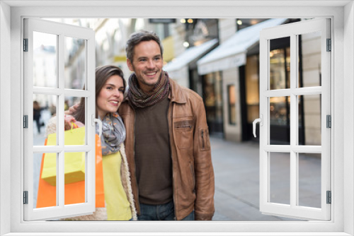 Stylish couple standing in a cobbled car-free street. 