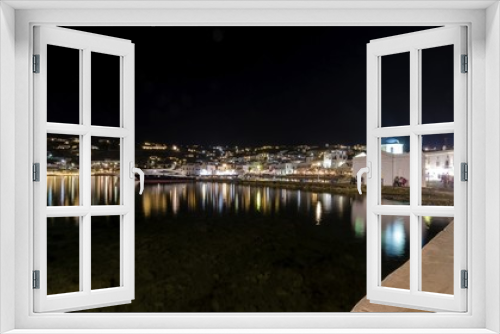 Fototapeta Naklejka Na Ścianę Okno 3D - Night view of Chora port in Mykonos,Greece.Hora town cityscape lights reflected on sea,whitewashed blue dome greek island church in the harbour and yachts anchored. A colourful and beautiful seascape.