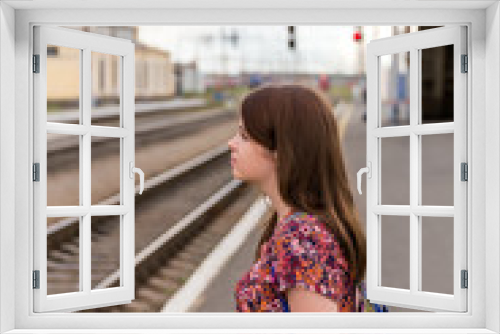 Young girl on train station platform with bags