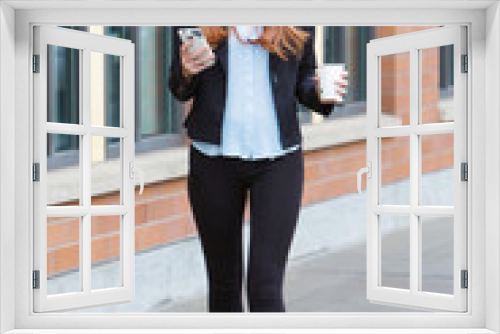 Redhead business woman on smart phone outside