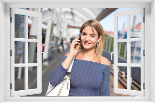 young woman on the train platform talking on the phone