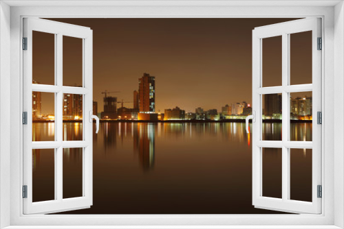 Fototapeta Naklejka Na Ścianę Okno 3D - A beautiful view of Bahrain skyline during night and its reflect