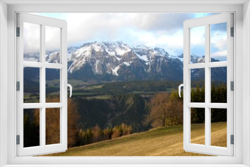 Fototapeta Naklejka Na Ścianę Okno 3D - Panoramic view on the early spring landscape in the mountains featuring green hills and snow covered mountain tops in the distance. Austrian Alps, ski resort Schladming.