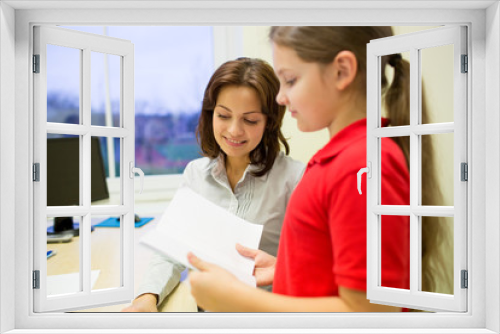 school girl with notebook and teacher in classroom